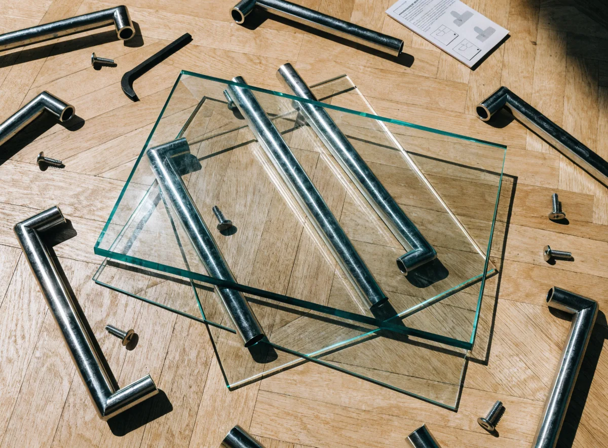 Detolf cabinet assembly with panels, hardware, and screwdriver on a clean floor